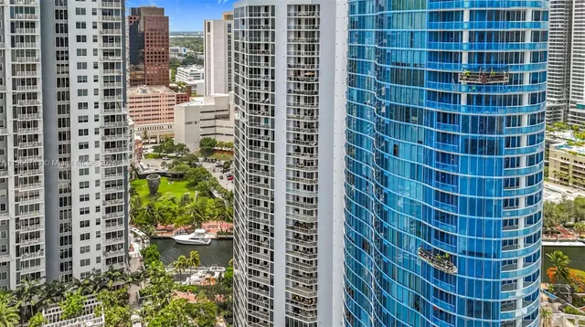 a living room with furniture a flat screen tv and a floor to ceiling window
