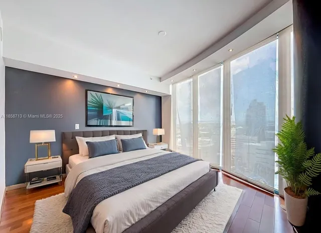 a bedroom with a large bed and a potted plant