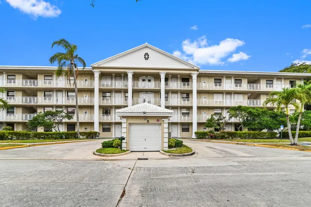 a front view of a building with a garden and entryway