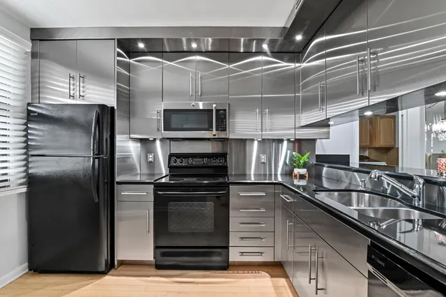 a kitchen with kitchen island a counter top space a sink and stainless steel appliances