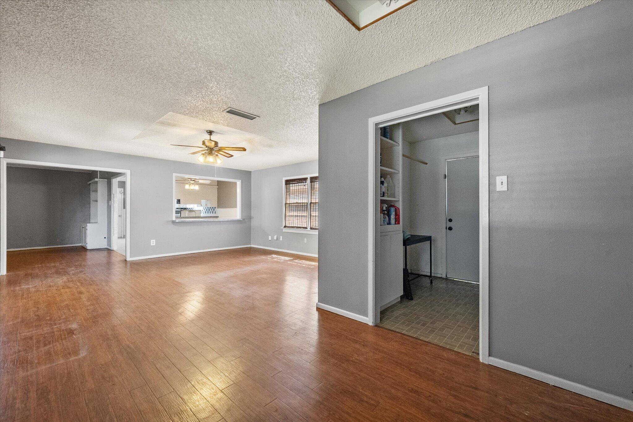 4604 27th Street Lubbock, TX 79410 - Photo 30 of 36 an empty room with wooden floor chandelier and windows