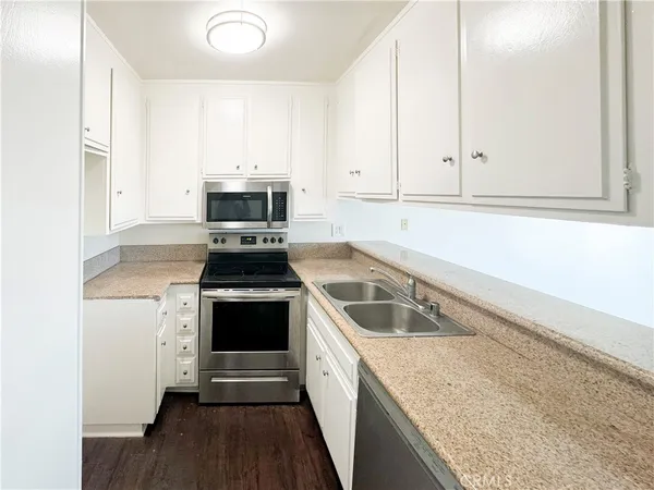 a kitchen with granite countertop a stove and a sink