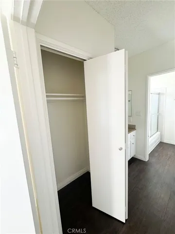 a view of walk in closet with wooden floor
