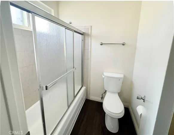 a utility room with dryer washer and wooden floor