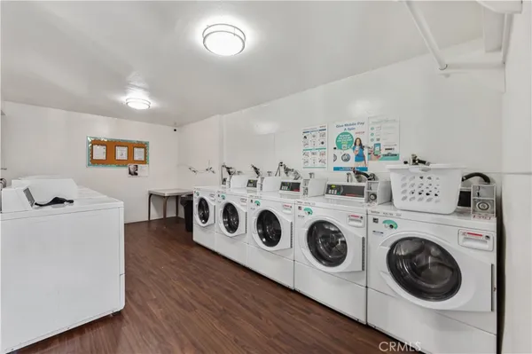a utility room with dryer washer and wooden floor