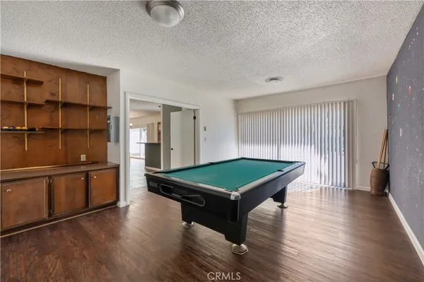a room with wooden floors and pool table
