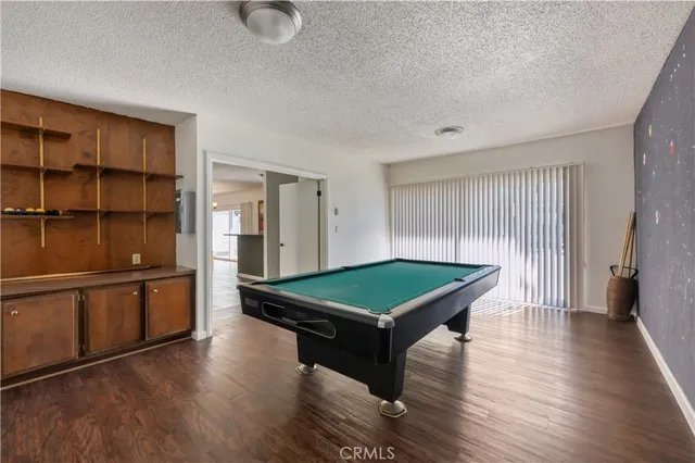 a room with wooden floors and pool table