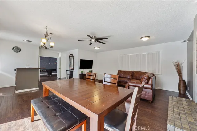 a dining room with wooden floor and a chandelier