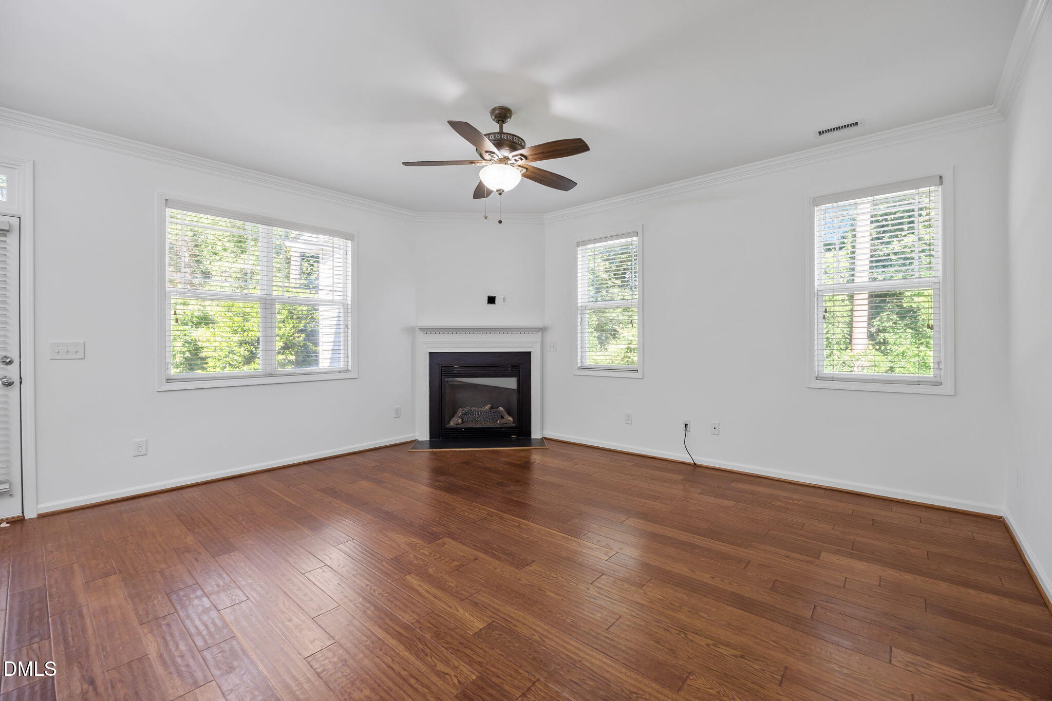 4724 Altha Street Raleigh, NC 27606 - Photo 16 of 43 an empty room with windows chandelier fan and fireplace