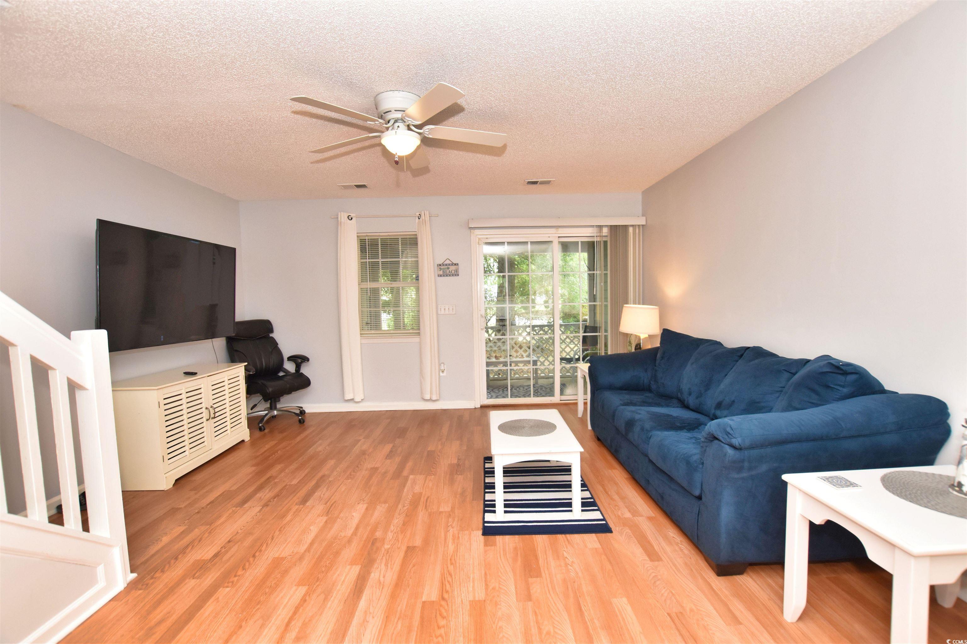1065 Pinwheel Loop, Unit 1065 Myrtle Beach, SC 29577 - Photo 10 of 27 Living room featuring light hardwood / wood-style floors, a textured ceiling, and ceiling fan