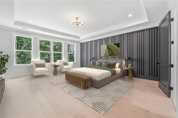 a bedroom with a large bed a chandelier and window