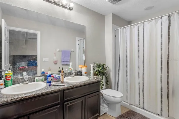 a bathroom with a granite countertop toilet sink and mirror