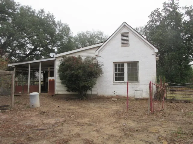 a view of a house with a yard and large tree