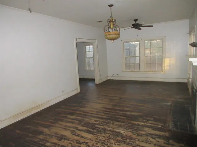 an empty room with wooden floor and staircase