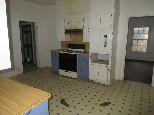 a kitchen with granite countertop a stove a sink and a refrigerator