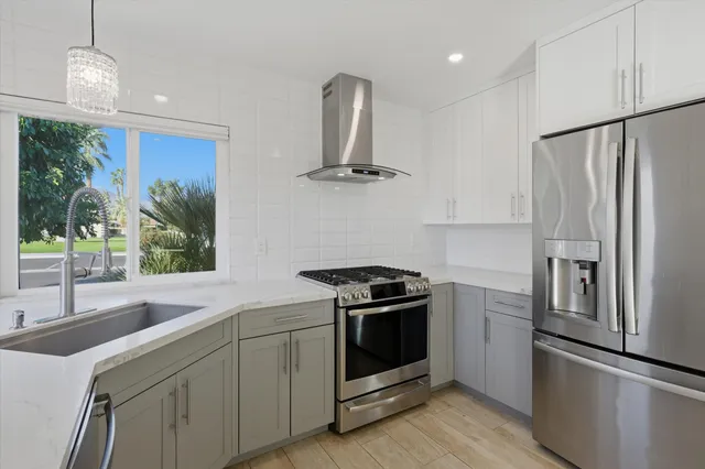 a kitchen with stainless steel appliances granite countertop a refrigerator sink and stove