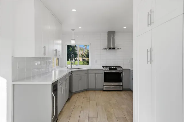 a kitchen with kitchen island white cabinets and stainless steel appliances