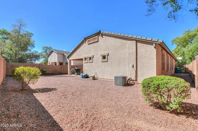 a backyard of a house with table and chairs