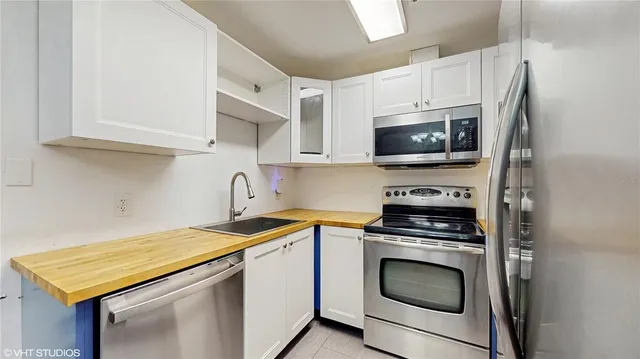 a kitchen with stainless steel appliances a stove microwave and sink