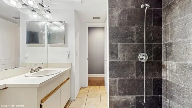 a bathroom with a shower a sink a mirror and shower