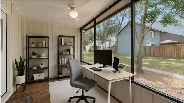 a view of a workspace with furniture and a window