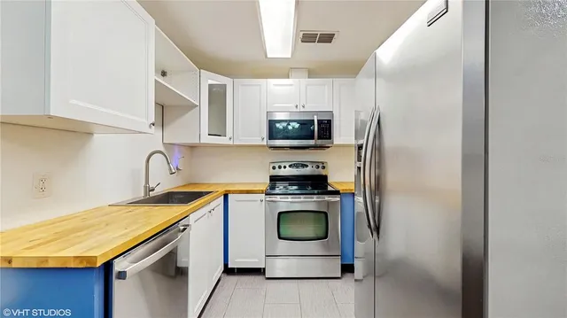 a kitchen with stainless steel appliances granite countertop a stove a sink and a refrigerator