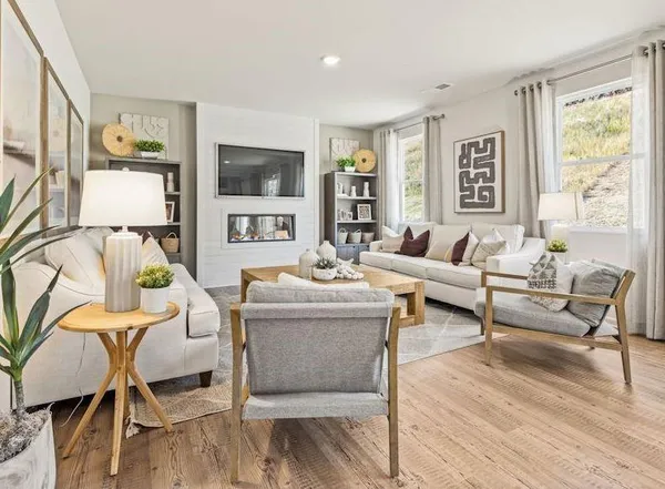 a living room with furniture a flat screen tv and a floor to ceiling window