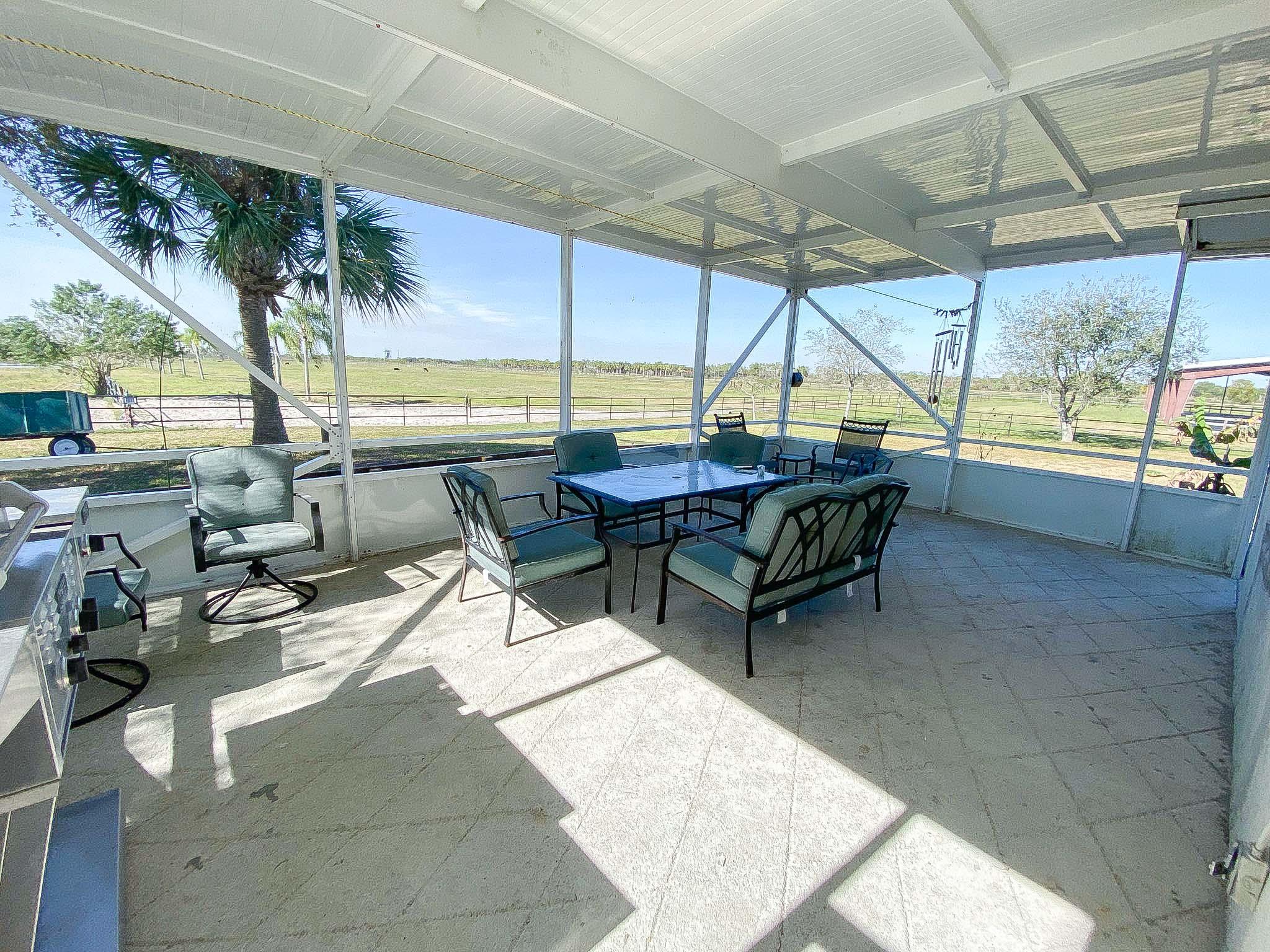 3715 Flying Cow Ranch Road Wellington, FL 33470 - Photo 19 of 33 a building outdoor space with patio furniture and potted plants
