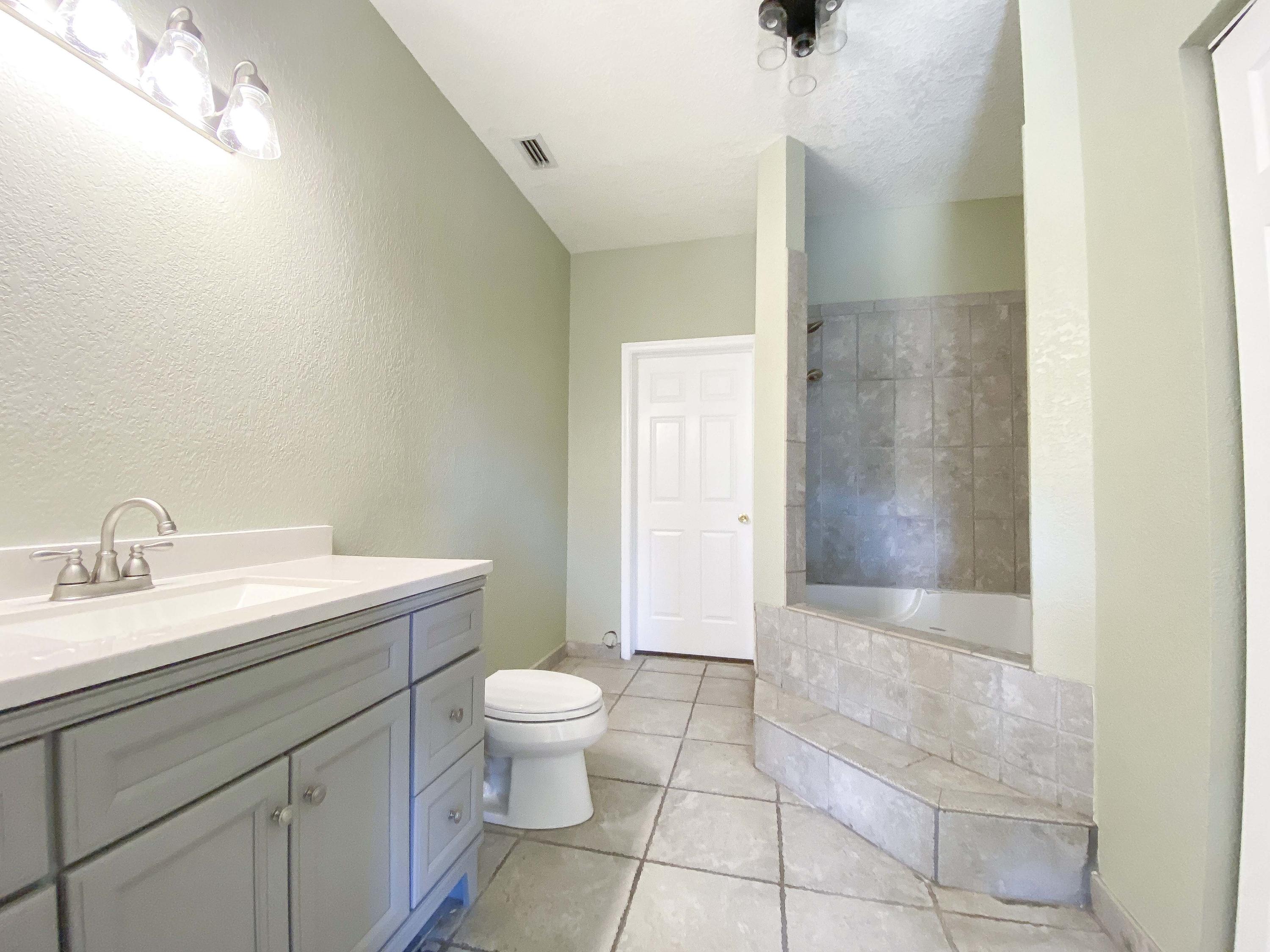 3715 Flying Cow Ranch Road Wellington, FL 33470 - Photo 22 of 33 a bathroom with a granite countertop sink a toilet and shower