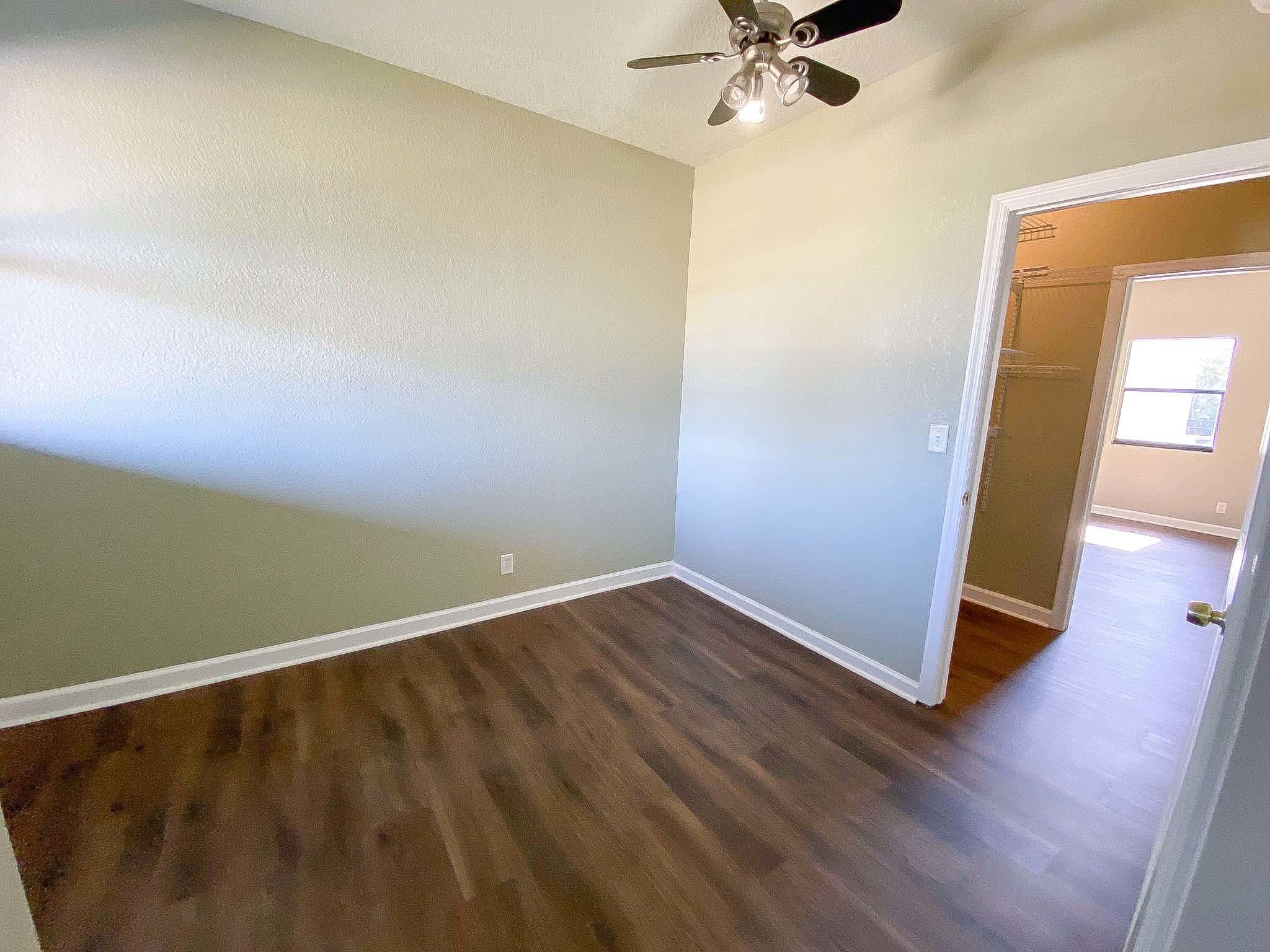 3715 Flying Cow Ranch Road Wellington, FL 33470 - Photo 29 of 33 an empty room with wooden floor fan and windows