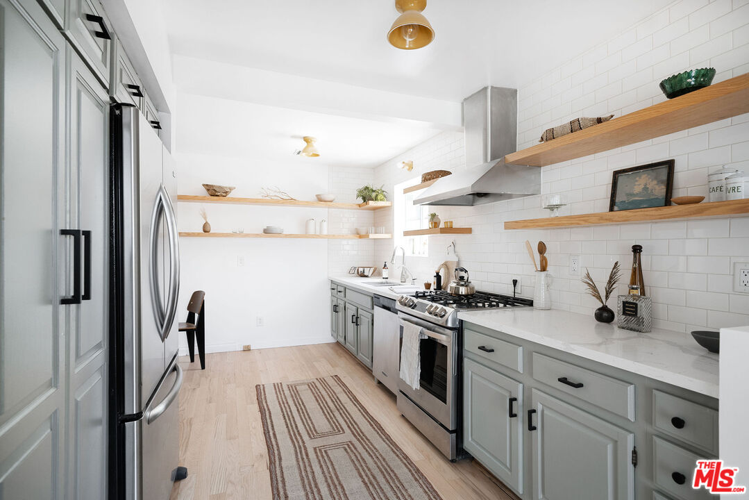 230 Marathon Road Altadena, CA 91001 - Photo 7 of 46 a kitchen with stainless steel appliances white cabinets and wooden floor