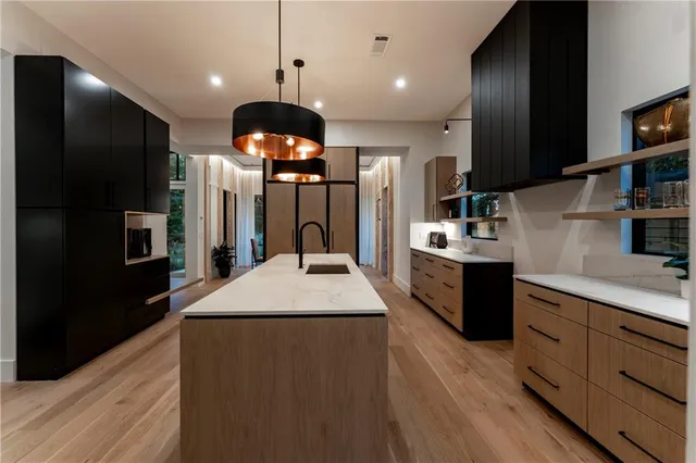 a large kitchen with a center island wooden floor appliances and a window