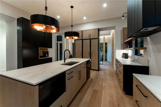 a kitchen with stainless steel appliances granite countertop a sink a stove and a refrigerator