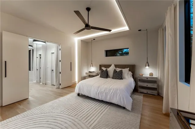 a bedroom with a large bed and windows