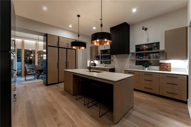 a kitchen with stainless steel appliances granite countertop a sink a stove and a refrigerator