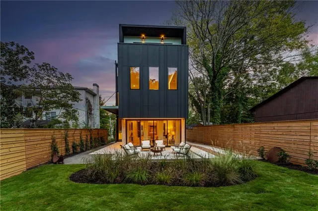 a view of a house with backyard and sitting area