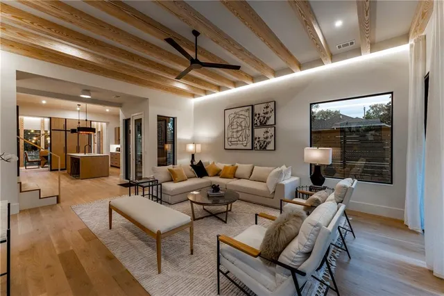 a living room with furniture a ceiling fan and a large window