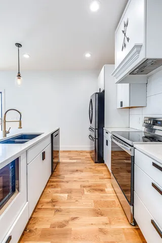 a kitchen with stainless steel appliances a sink and cabinets
