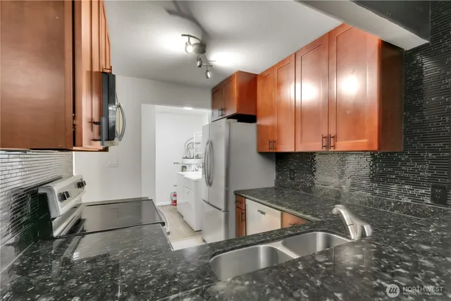 a view of a kitchen with stainless steel appliances granite countertop cabinets and a sink