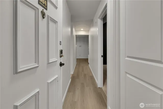 a view of a hallway with wooden floor and staircase