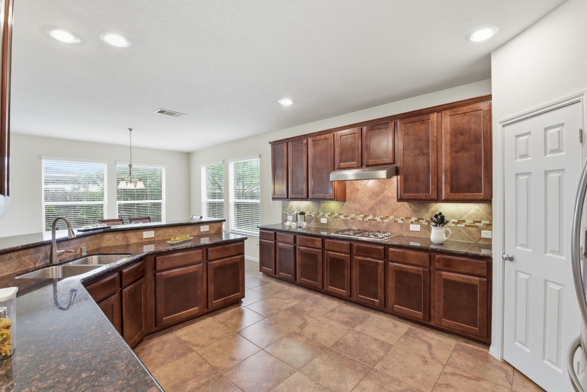 3301 Remington Rise Lane Katy, TX 77494 - Photo 11 of 50 a large kitchen with kitchen island granite countertop a stove sink and cabinets