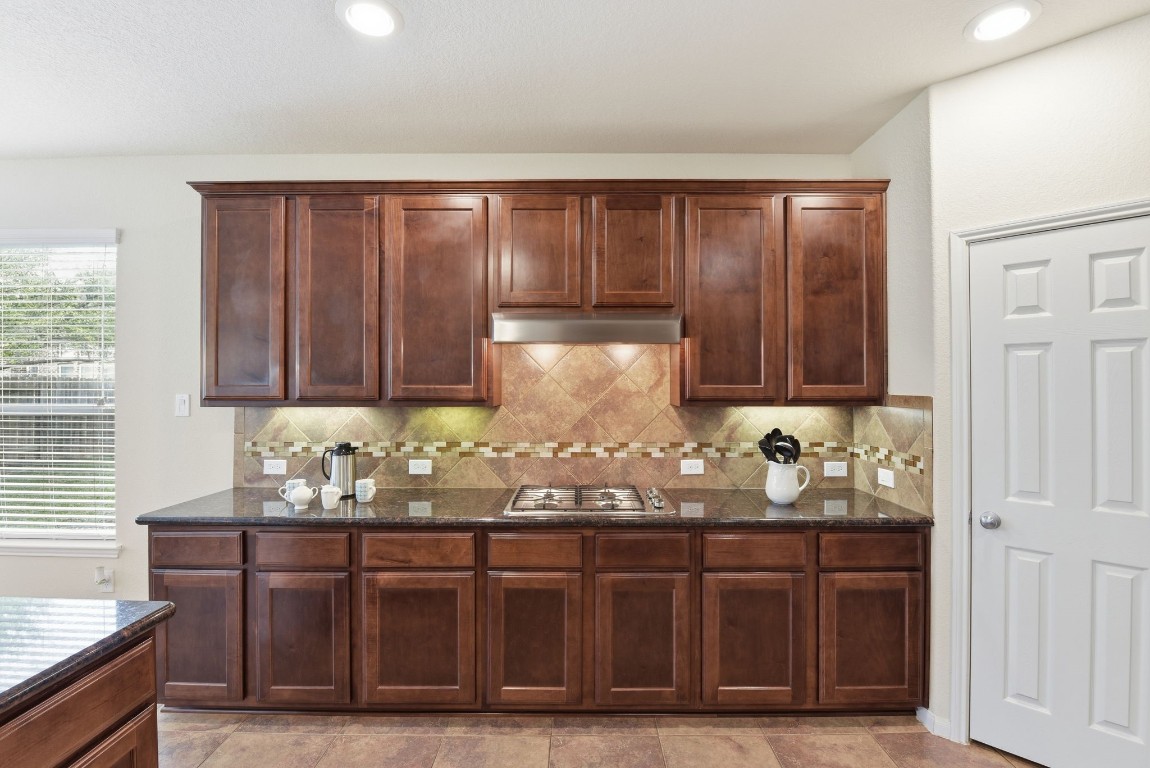 3301 Remington Rise Lane Katy, TX 77494 - Photo 12 of 50 a kitchen with granite countertop wooden cabinets and sink