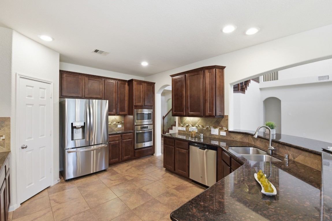 3301 Remington Rise Lane Katy, TX 77494 - Photo 13 of 50 a kitchen with refrigerator and wooden cabinets