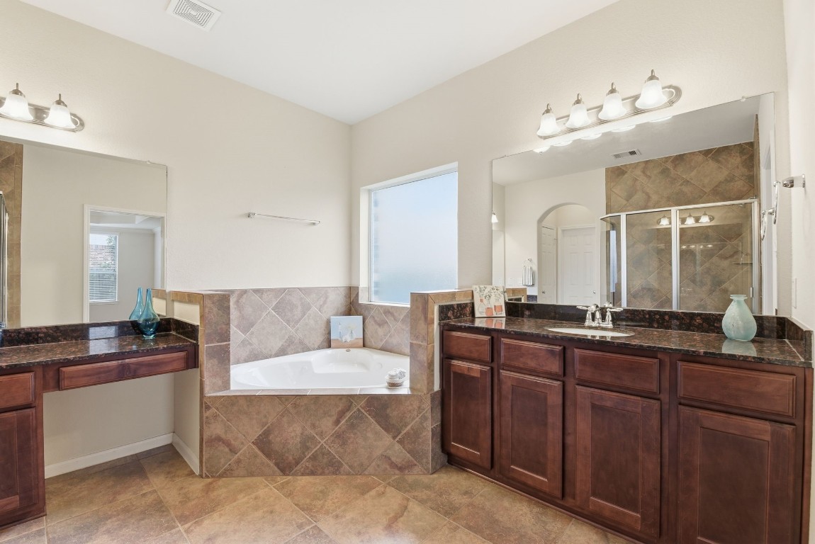 3301 Remington Rise Lane Katy, TX 77494 - Photo 24 of 50 a spacious bathroom with a granite countertop sink a mirror and a bathtub