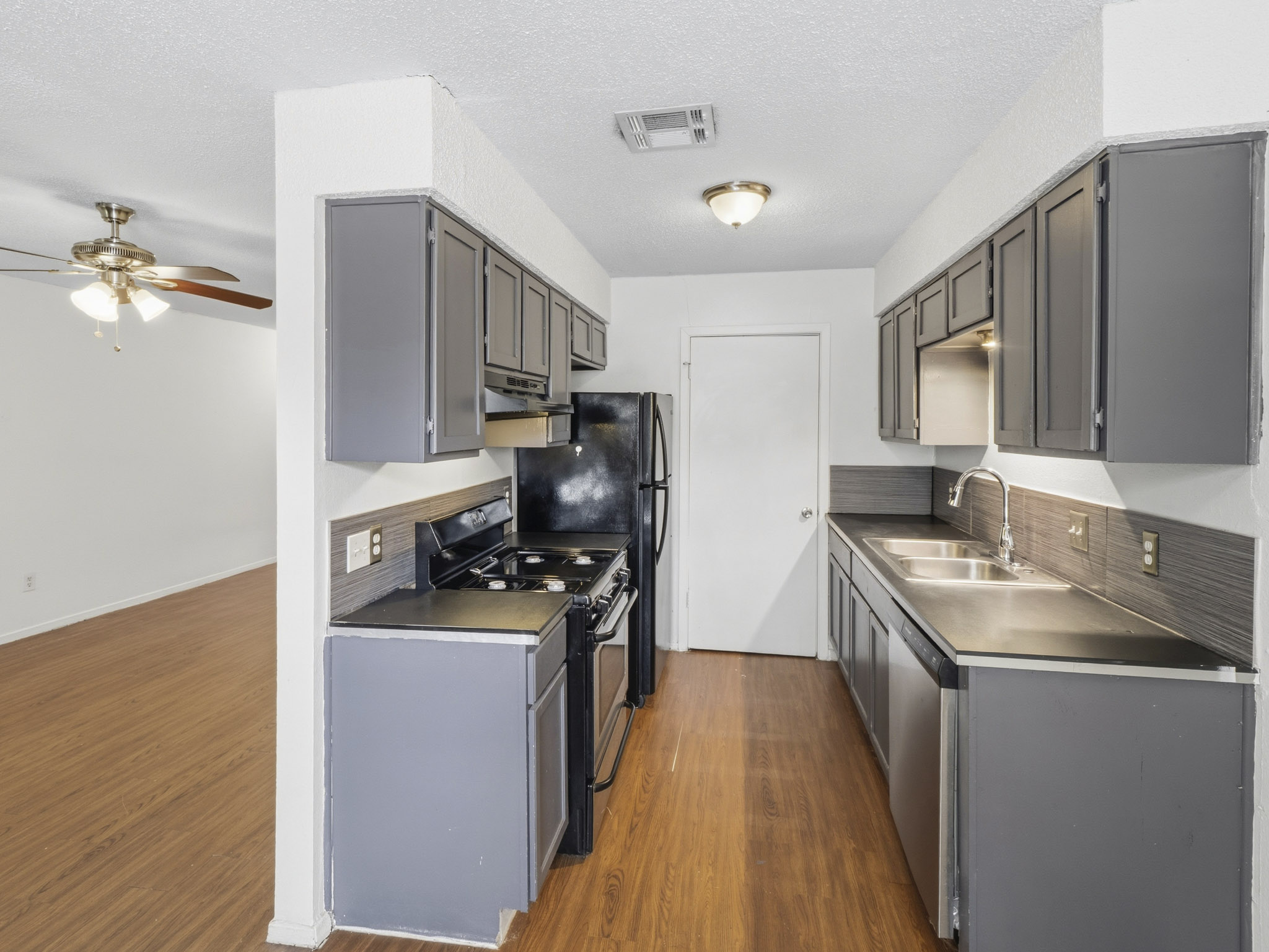 2401 Burleson Road Austin, TX 78741 - Photo 6 of 25 Functional kitchen with sleek grey cabinetry and durable countertops, ready for daily living.