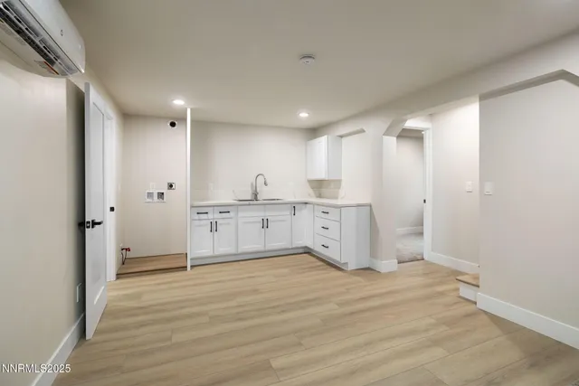 a large white kitchen with a sink and refrigerator
