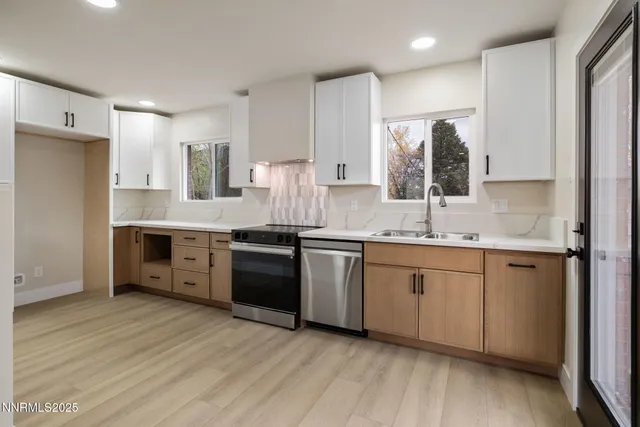 a kitchen with stainless steel appliances granite countertop a sink a stove a refrigerator and cabinets