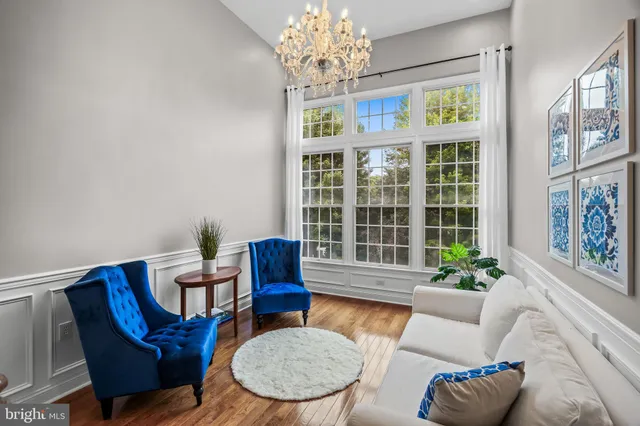 a living room with furniture chandelier and a window