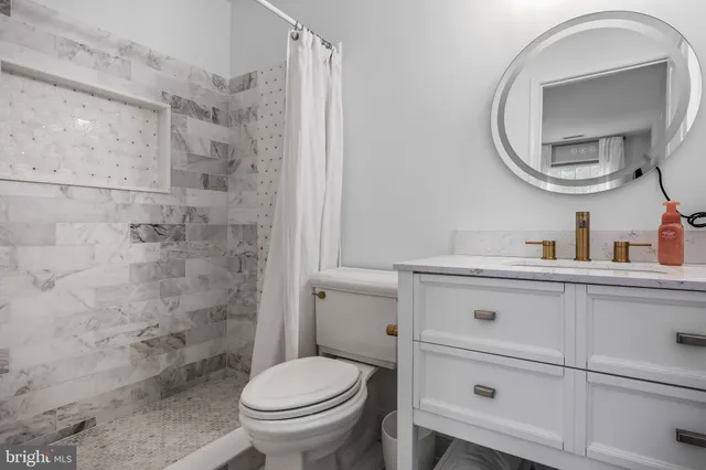 a bathroom with a sink a toilet and a mirror