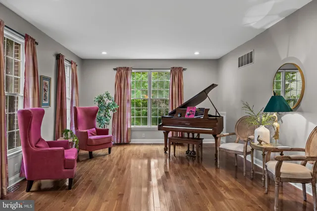 a living room with furniture a rug potted plant and a window